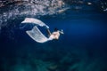 Woman with white freediving fins swim in surface underwater in ocean