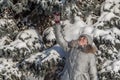 A woman with white frozen eyelashes and red cheeks in a gray hat and gray coat in a winter park Royalty Free Stock Photo