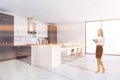 Woman in white and gray kitchen with table Royalty Free Stock Photo