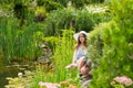 Woman in white hat sitting on a rock near the lake Royalty Free Stock Photo