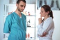 Woman in white lab coat and man in medical apparel.