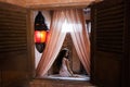 Woman in white lingerie relaxing near stone bath full foam in moroccan bathroom