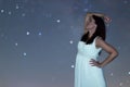 Woman in white long dress under starry night. Woman looking to starry night. Woman under night sky, Royalty Free Stock Photo