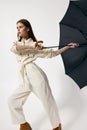 Woman in white overalls holding an umbrella from the wind basing isolated background Royalty Free Stock Photo