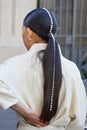 Woman with white pearls decoration on head before Salvatore Ferragamo fashion show, Milan