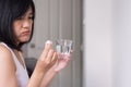 Woman with white pills on hand and a glass of water,Sick female taking medicines Royalty Free Stock Photo