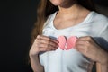 Woman in white shirt holding paper broken heart on chest Royalty Free Stock Photo