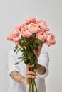 Girl holding flowers in her hands isolated on white background.