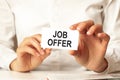 Woman in a white shirt holds a piece of paper with the text: job offer. business concept Royalty Free Stock Photo