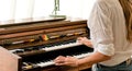 Woman with white shirt play the electone in her room and look relax and happy in the morning