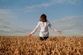 A woman in white shirt in rye field. View from the back. The concept of harmony Royalty Free Stock Photo