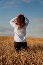 A woman in white shirt in rye field. View from the back. The concept of harmony Royalty Free Stock Photo