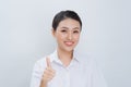 Woman in a white shirt showing thumb up sign and smiling at the camera Royalty Free Stock Photo