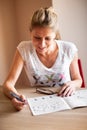 Woman sitting and solving crossword puzzles