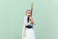 Woman in white shirt and skirt blouse with eyeglasses standing with closed eyes and embracing guitar Royalty Free Stock Photo