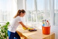 Woman in white shirt and yellow protective rubber gloves cleaning at home and wiping dust with pink rag on laptop computer. Royalty Free Stock Photo