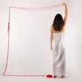 Woman white silk nightie making frame with red thread on white background