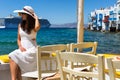 Woman in white sits at the waterfront of Little Venice in Mykonos Royalty Free Stock Photo