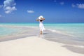 A woman in a white summer dress stands on a sandbar Royalty Free Stock Photo