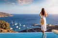 A woman in white summer dress by the swimming pool enjoys the sunset Royalty Free Stock Photo