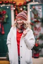 Woman in white sute red .pullover smiling in new year decoration near home