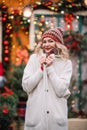 Woman in white sute red .pullover smiling in new year decoration near home with bright light