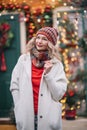 Woman in white sute red .pullover smiling in new year decoration near home with bright light