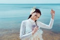 Woman in white swan costume standing near water, looking at camera Royalty Free Stock Photo