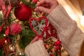 Woman hangs heart shaped Christmas ornament Royalty Free Stock Photo