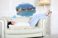 Woman in white sweater lies on sofa and dreams