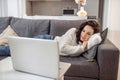 A woman in white sweater lying on the sofa and watching something online Royalty Free Stock Photo