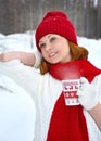 A woman in a white sweater and red scarf and hat is holding a winter cup close up. Winter and christmas time concept Royalty Free Stock Photo