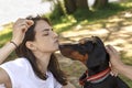 Woman in white t-shirt and black young doberman sit opposite each other Royalty Free Stock Photo