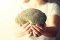 Woman in white T-shirt holding broccoli in hands. Copy space. Healthy clean detox eating concept. Vegetarian, vegan, raw Royalty Free Stock Photo