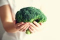 Woman in white T-shirt holding broccoli in hands. Copy space. Healthy clean detox eating concept. Vegetarian, vegan, raw Royalty Free Stock Photo