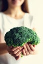 Woman in white T-shirt holding broccoli in hands. Copy space. Healthy clean detox eating concept. Vegetarian, vegan, raw Royalty Free Stock Photo