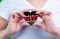 Woman in white t-shirt holds a heart in the form flag Kenya on her chest.