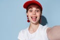 woman in white t-shirt red cap fashion summer style posing blue background Royalty Free Stock Photo