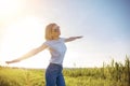 Woman in white T-shirt, sunglasses and jeans spread apart arms mimicking airplane at sunset. Summer. Vacation air travel Royalty Free Stock Photo