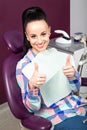 Woman with white teeth with thumbs up waiting for dentist