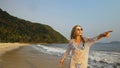 Woman in a white tunic on the beach, near the stormy sea. Blonde Royalty Free Stock Photo