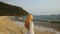 Woman in a white tunic on the beach, near the stormy sea. Blonde Royalty Free Stock Photo