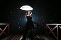 Woman with white umbrella in flash lights and rain drops Royalty Free Stock Photo