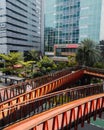 a woman in white is walking through the pedestrian bridge with a tall building in front of it Royalty Free Stock Photo