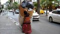 A woman who is a cardboard and trash collector pulls a wheelbarrow