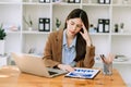 Woman who is tired and overthinking from working with tablet and laptop at modern office Royalty Free Stock Photo
