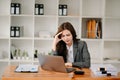 Woman who is tired and overthinking from working with tablet and laptop at modern office Royalty Free Stock Photo