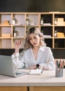 Woman who is tired and overthinking from working with tablet and laptop at modern office Royalty Free Stock Photo