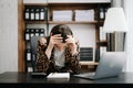 Woman who is tired and overthinking from working with tablet and laptop at modern office Royalty Free Stock Photo