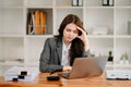 Woman who is tired and overthinking from working with tablet and laptop at modern office Royalty Free Stock Photo